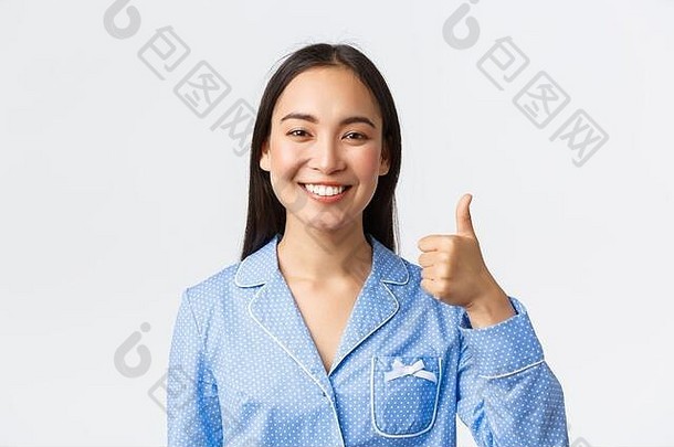 特写镜头满意漂亮的微笑亚洲女人蓝色的睡衣显示竖起大拇指批准推荐保证产品质量站