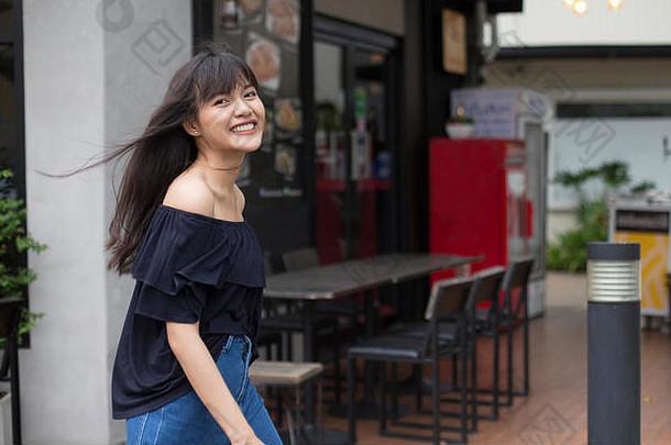 年轻的漂亮的亚洲女人走快乐餐厅背景