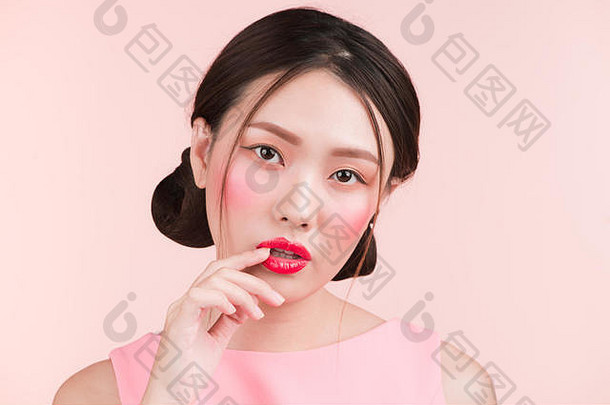 美丽的亚洲女孩专业化妆时尚的发型孤立的粉红色的化妆品化妆