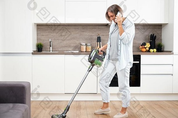年轻的女人吸尘地板上吸尘清洁房子