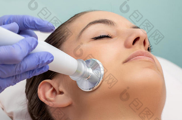 宏关闭女人面部消脂治疗师应用平头等离子体笔一边脸