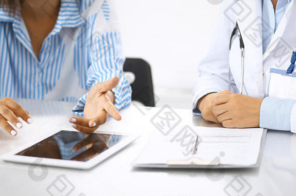 医生病人会说话的讨论健康治疗坐着桌子上医生指出平板电脑特写镜头医学健康护理概念