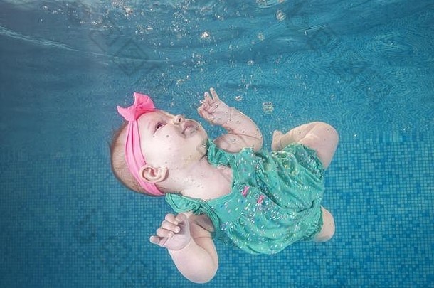 美丽的女孩绿色衣服游泳水下池