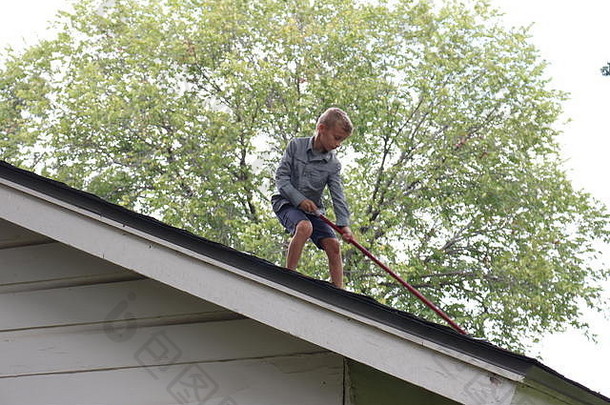 年轻的男孩刷牙棒屋顶