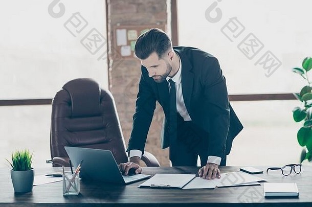 照片英俊的成功的业务的家伙打字笔记本键盘检查比较纸合同细节在线统计数据穿黑色的夹克衬衫领带西装