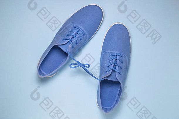 平躺蓝色的运动鞋系鞋带蓝色的柔和的蓝色的背景最小的概念