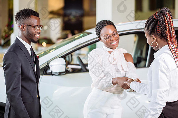 非洲客户购买车辆车经销商女人男人。握手