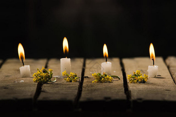 白色蜡蜡烛坐着木表面燃烧黑色的背景美丽的光设置