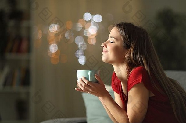 一边视图肖像放松女人喝咖啡坐着沙发上晚上首页