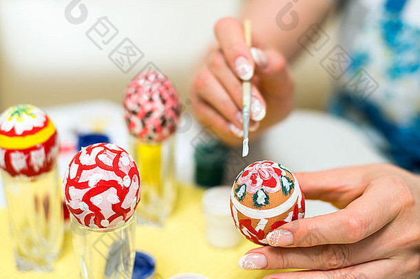 女人油漆复活节鸡蛋刷