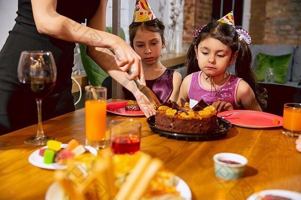 肖像快乐多民族家庭庆祝生日首页大家庭吃蛋糕喝酒问候有趣的孩子们庆祝活动家庭聚会，派对首页概念