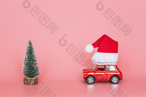 红色的玩具车圣诞老人他圣诞节树粉红色的纸背景冬天交付圣诞节快乐一年庆祝活动概念问候