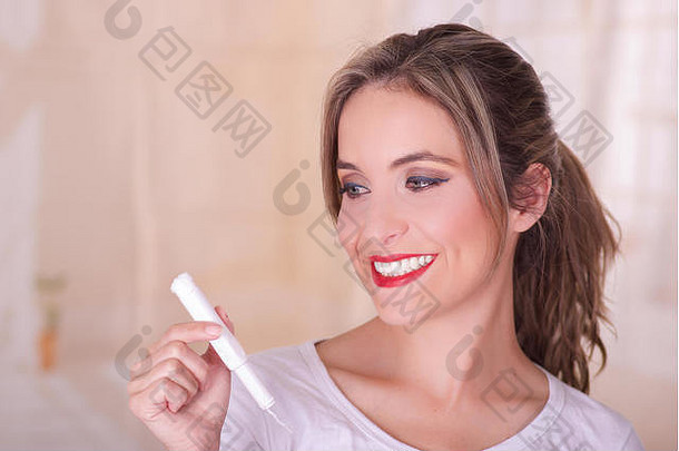 年轻的美丽的微笑女人持有月经棉花止血栓手模糊背景