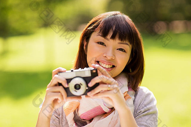 快乐年轻的亚洲女人电影相机在户外
