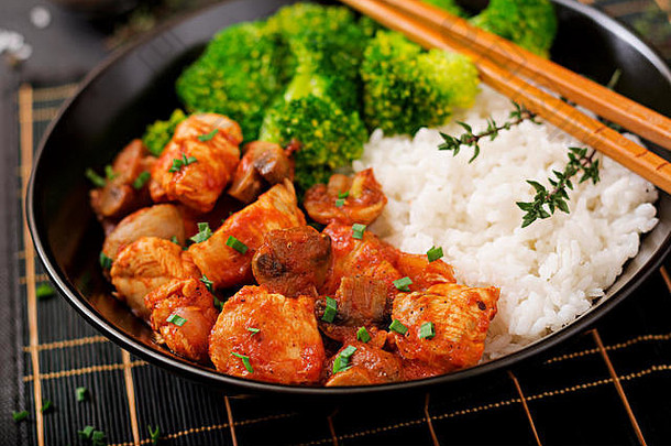块鸡角蘑菇红烧番茄酱汁煮熟的西兰花大米适当的营养健康的生活方式饮食菜单