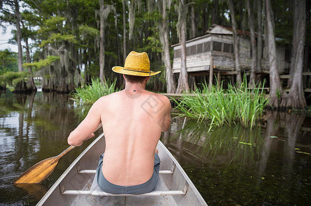 男人。划船沼泽河口场景美国南特色木小屋喀多人湖德州美国
