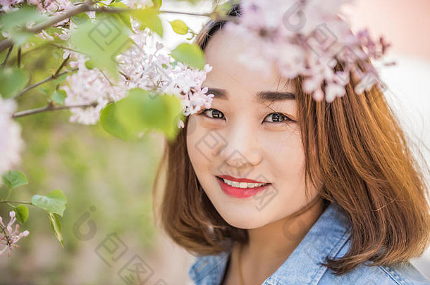 户外肖像美丽的快乐年轻的女人享受春天花