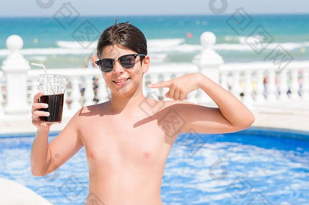 年轻的孩子喝苏打水假期游泳池海滩快乐指出手手指