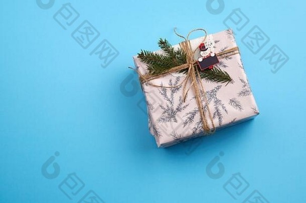 礼物包装粉红色的纸系棕色（的）绳子装饰绿色云杉分支蓝色的背景前视图