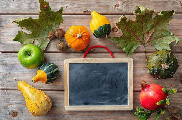 感恩节概念色彩斑斓的南瓜水果空白黑板上乡村木背景复制空间前视图
