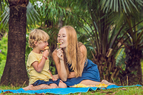 妈妈儿子野餐公园吃健康的水果芒果<strong>菠萝</strong>瓜孩子们吃健康的食物