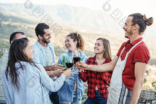 集团快乐朋友欢呼敬酒红色的酒眼镜阳台年轻的人有趣的喝晚餐聚会，派对天井