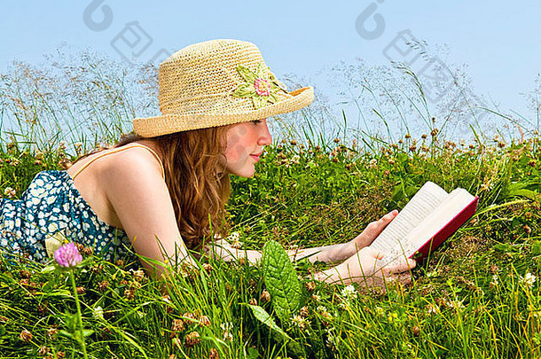 年轻的十几岁的女孩阅读书夏天草地稻草他