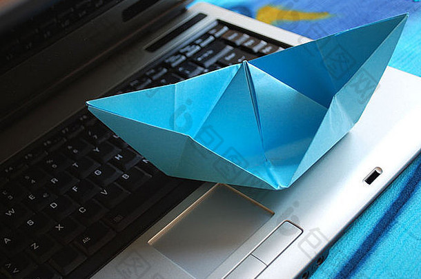 蓝色的纸船航行移动PC假期概念网络冲浪概念