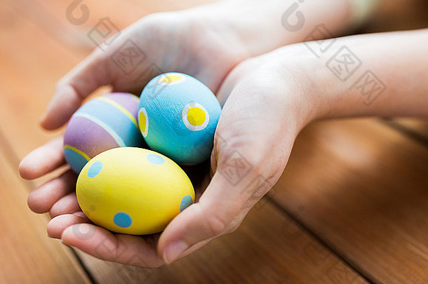 关闭女人手彩色的复活节鸡蛋