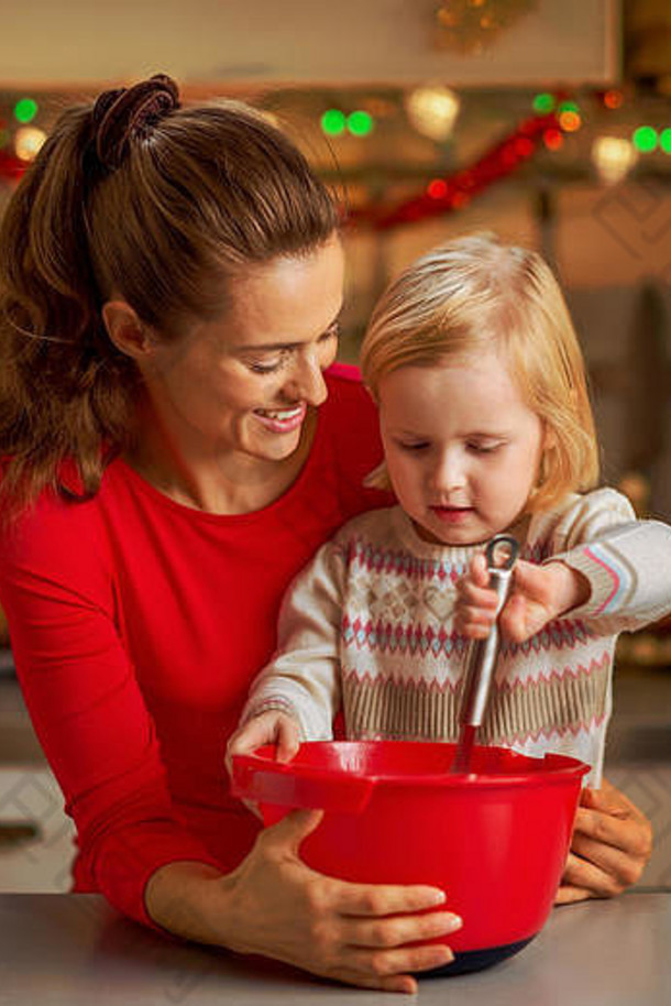 快乐妈妈。婴儿搅拌面团圣诞节装饰厨房