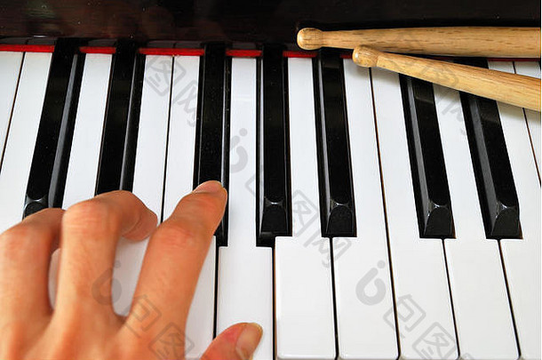 左手玩黑色的白色计划键盘鼓棒概念音乐创造力