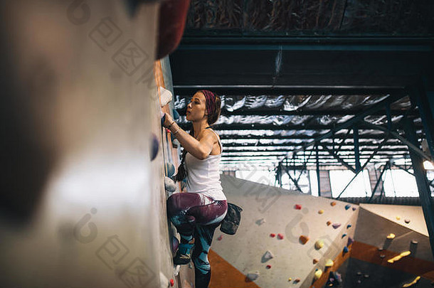 女人抱石室内攀爬中心登山者练习岩石攀爬室内攀爬健身房