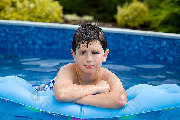 快乐年轻的男孩充气水懒人游泳池