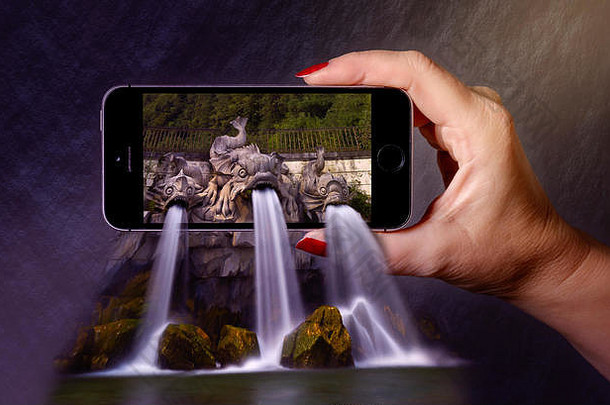 流行瀑布形式树石头鱼手持有移动电话效果
