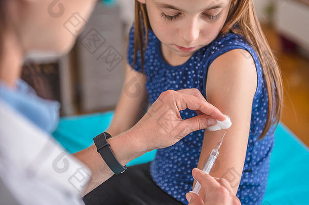 儿科女医生给年轻的女孩疫苗拍摄手臂