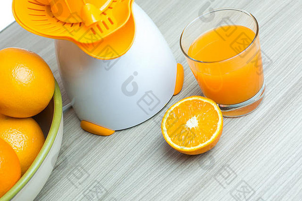 玻璃挤压橙色汁新鲜的多汁的橙子木表格