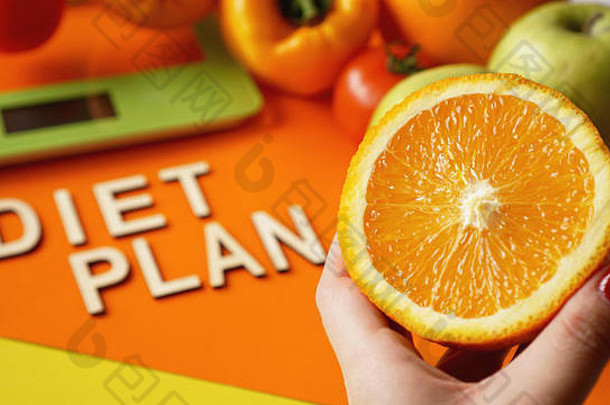 概念饮食健康的食物厨房重量规模蔬菜水果刻字饮食计划橙色背景