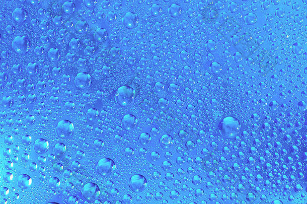 蓝色的湿多雨的背景水滴透明的玻璃
