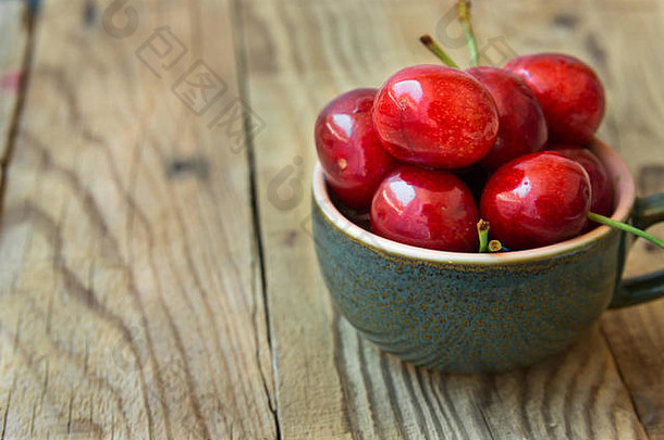 群新鲜的成熟的色彩斑斓的光滑的甜蜜的樱桃陶瓷茶杯木背景极简主义复制空间文本夏天健康的食物素食主义者