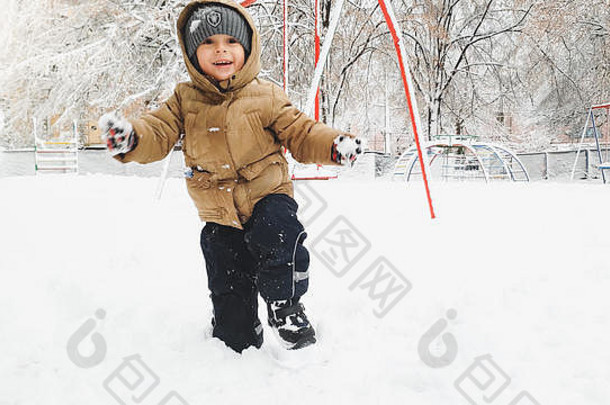 特写镜头照片<strong>微笑</strong>可爱的男孩外套他有趣的玩雪冬天降雪玩雪球操场上