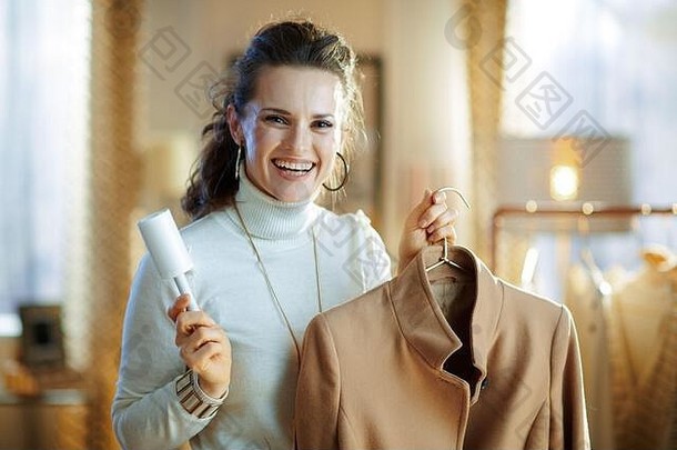 准备冷季节肖像微笑年轻的女人白色毛衣裙子清洁外套悬挂器线头辊现代首页阳光明媚的