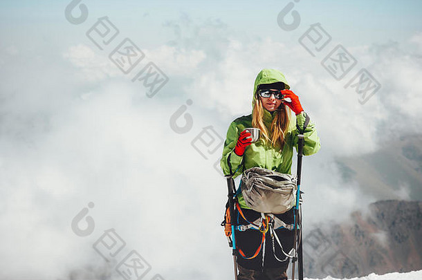 女人登山者喝茶山峰会旅行生活方式冒险概念活跃的假期户外登山体育运动云背景