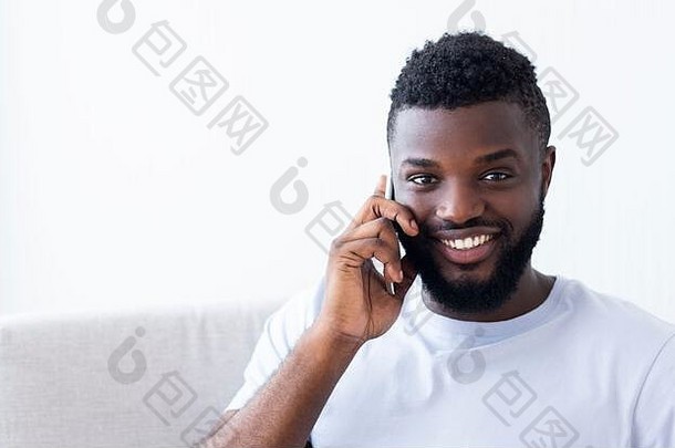 微笑非洲美国男人。会说话的手机