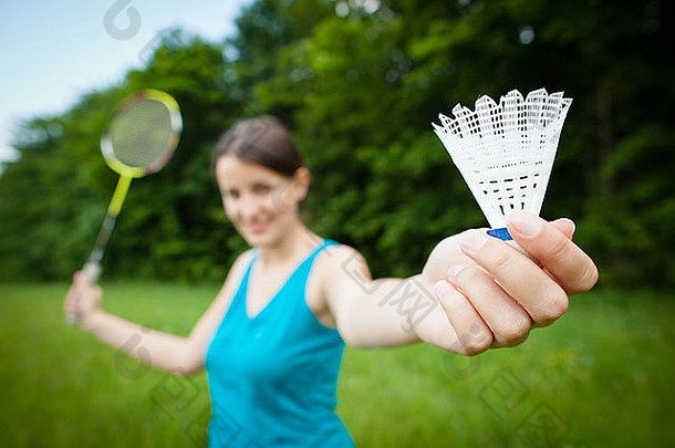漂亮的年轻的女人玩羽毛球城市公园可爱的夏天一天浅景深