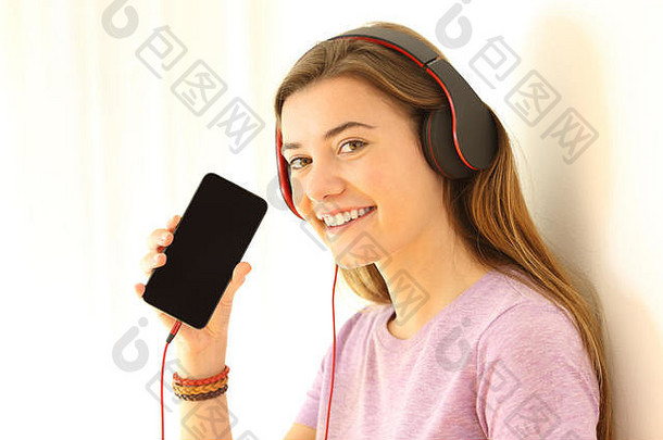 肖像快乐青少年听音乐显示空白聪明的电话屏幕孤立的一边