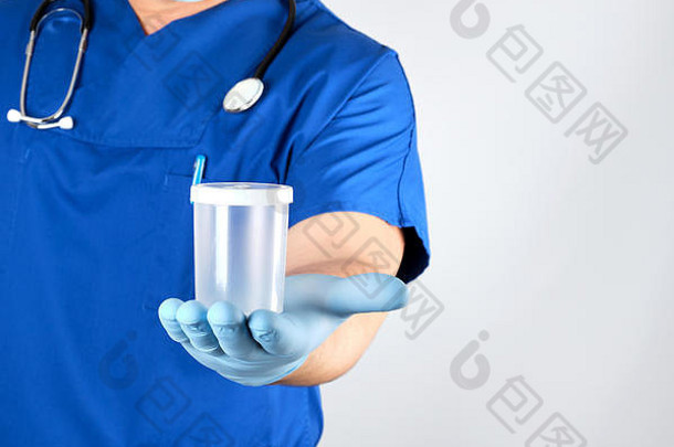 医生蓝色的统一的乳胶手套持有空塑料容器采取尿液样品白色背景
