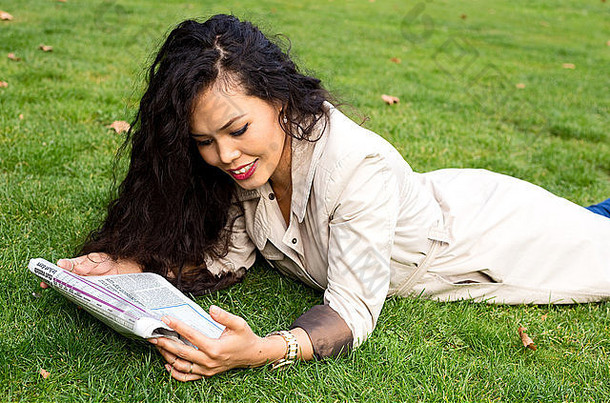 年轻的女人阅读纸公园