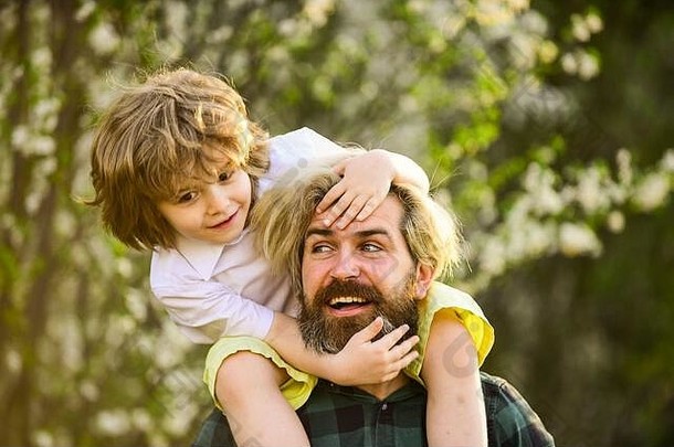 家庭有趣的家庭小孩子拥抱爸爸父亲儿子樱花树开花快乐父亲一天庆祝儿童一天家庭爱值放松户外