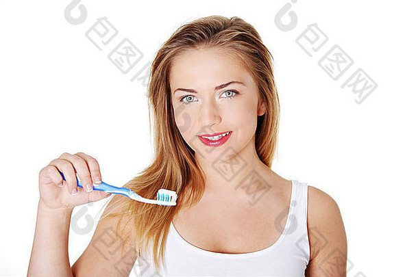 美丽的金发碧眼的青少年女人刷牙牙齿