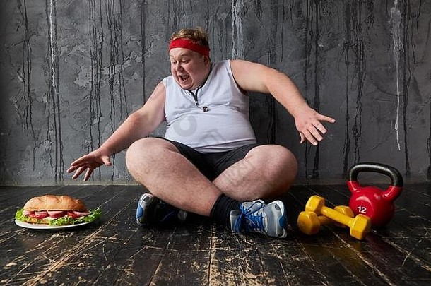 肥胖年轻的高加索人男人。严重损害了大三明治脂肪男人。坚持健康的生活方式饮食